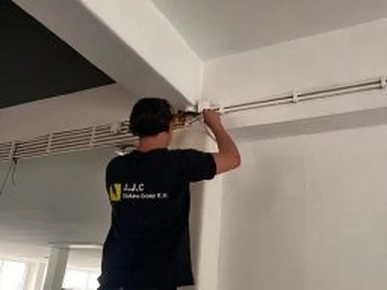 Monteur monteert een kabelgoot tegen het plafond