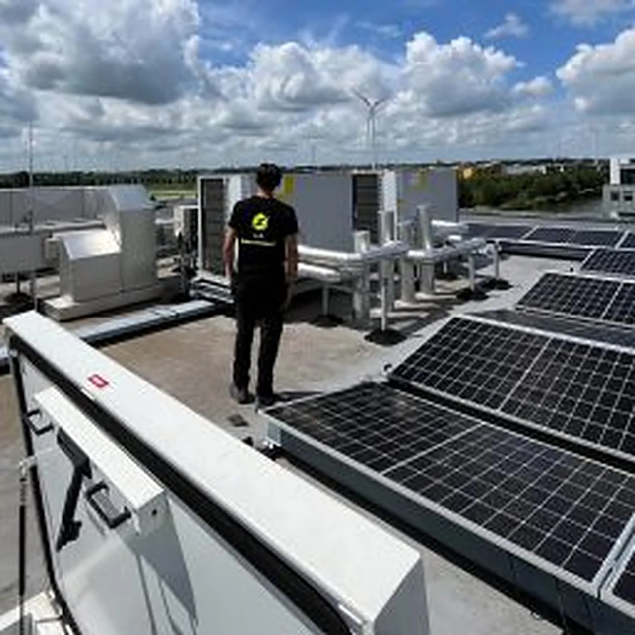 Monteur van J.J.C. bij zonnepanelen op een bedrijfsdak